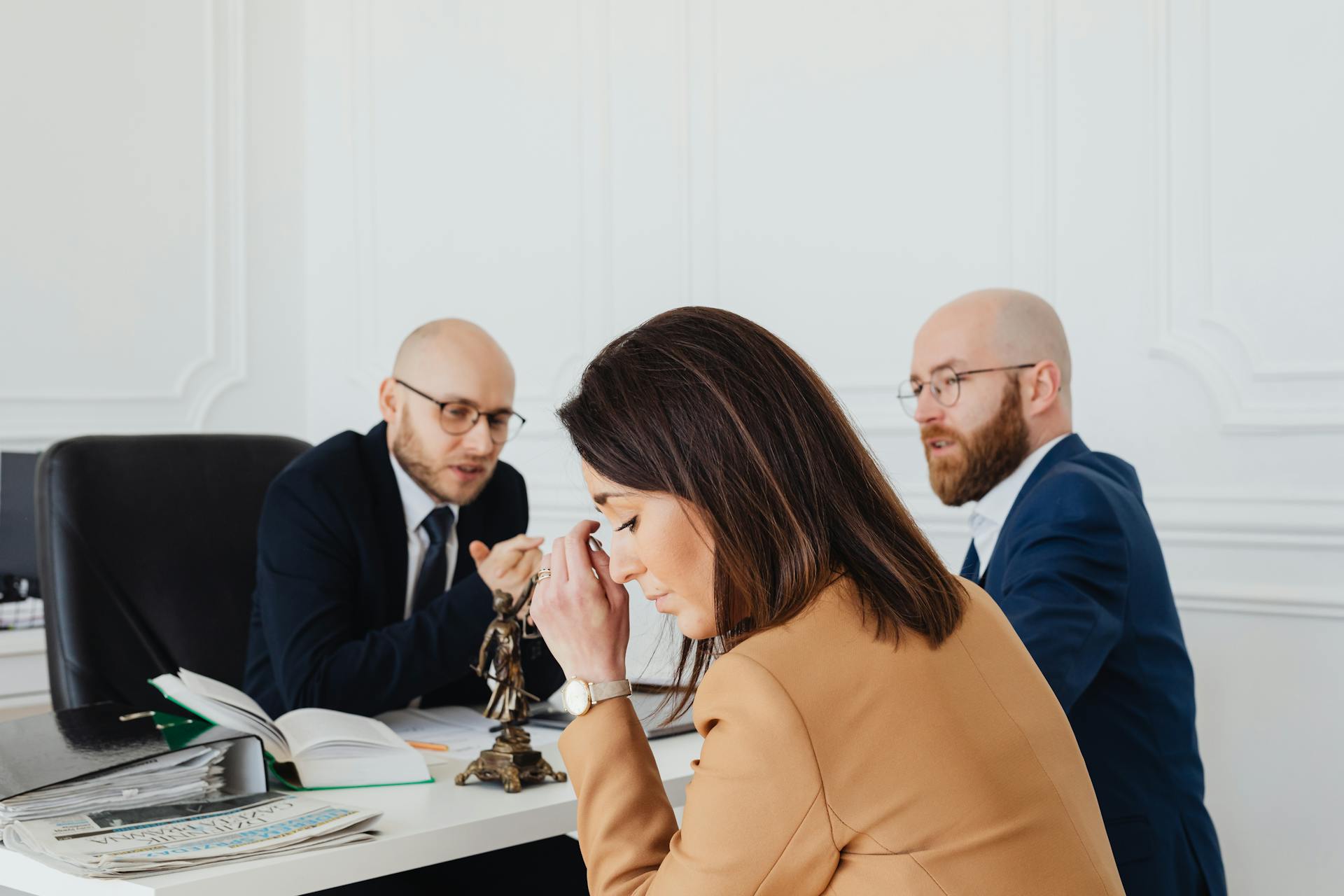 A tense discussion among lawyers and a client in an office setting.