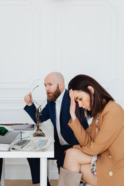 Free Woman in Brown Blazer Sitting with Her Hand on the Forehead  Stock Photo