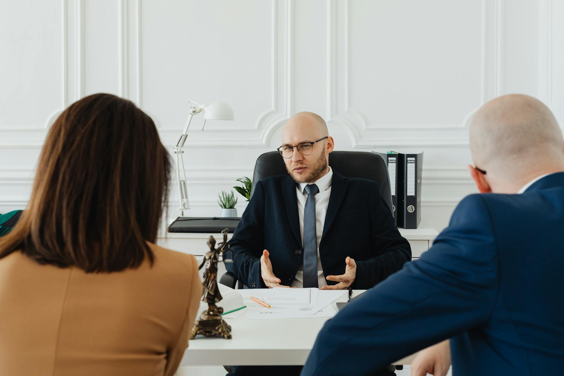 A professional business meeting with a lawyer and clients in a modern office setting.