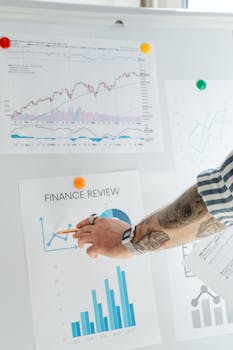 Man examining financial data charts on a whiteboard in an office setting.