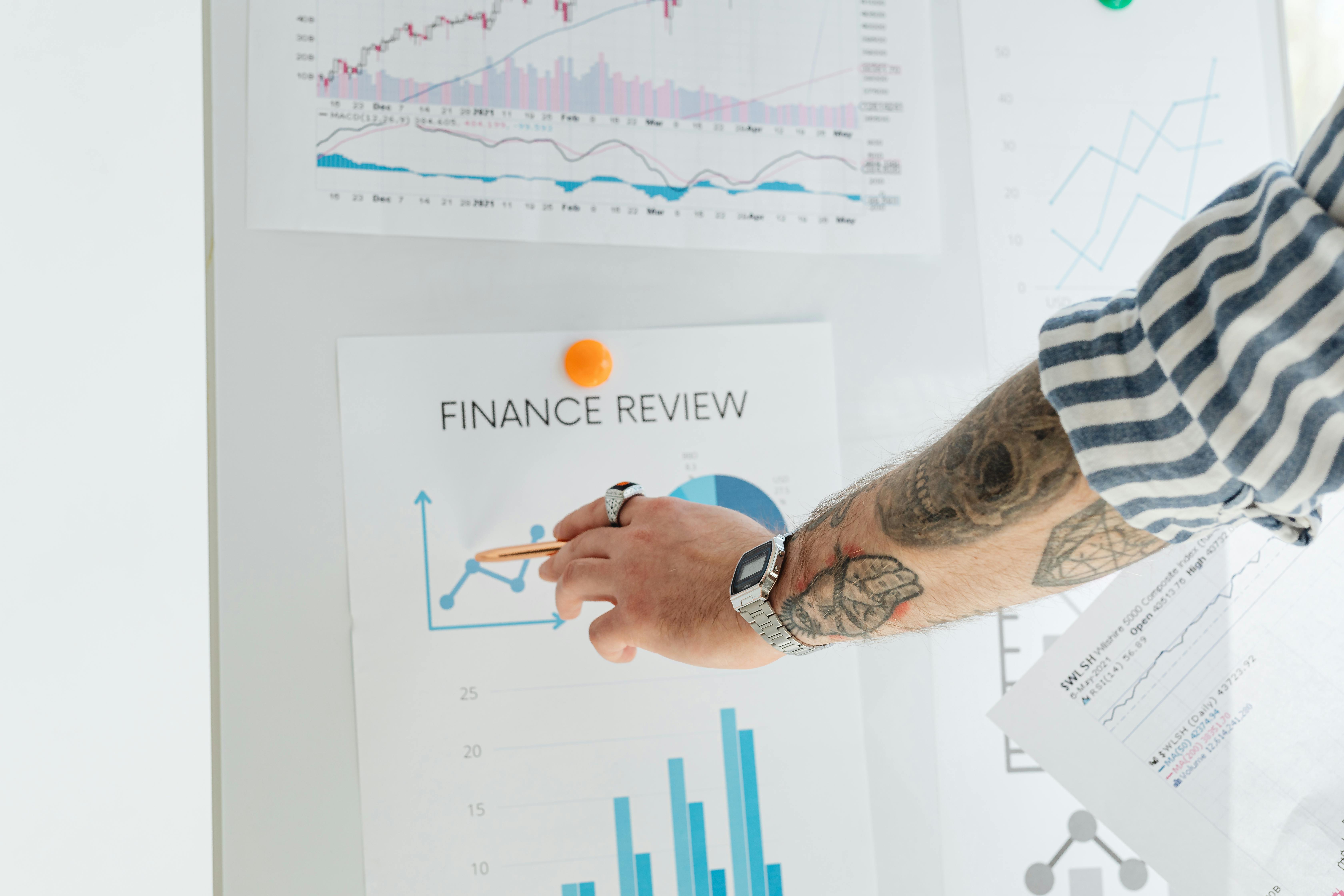 a person holding a pen showing finance review chart