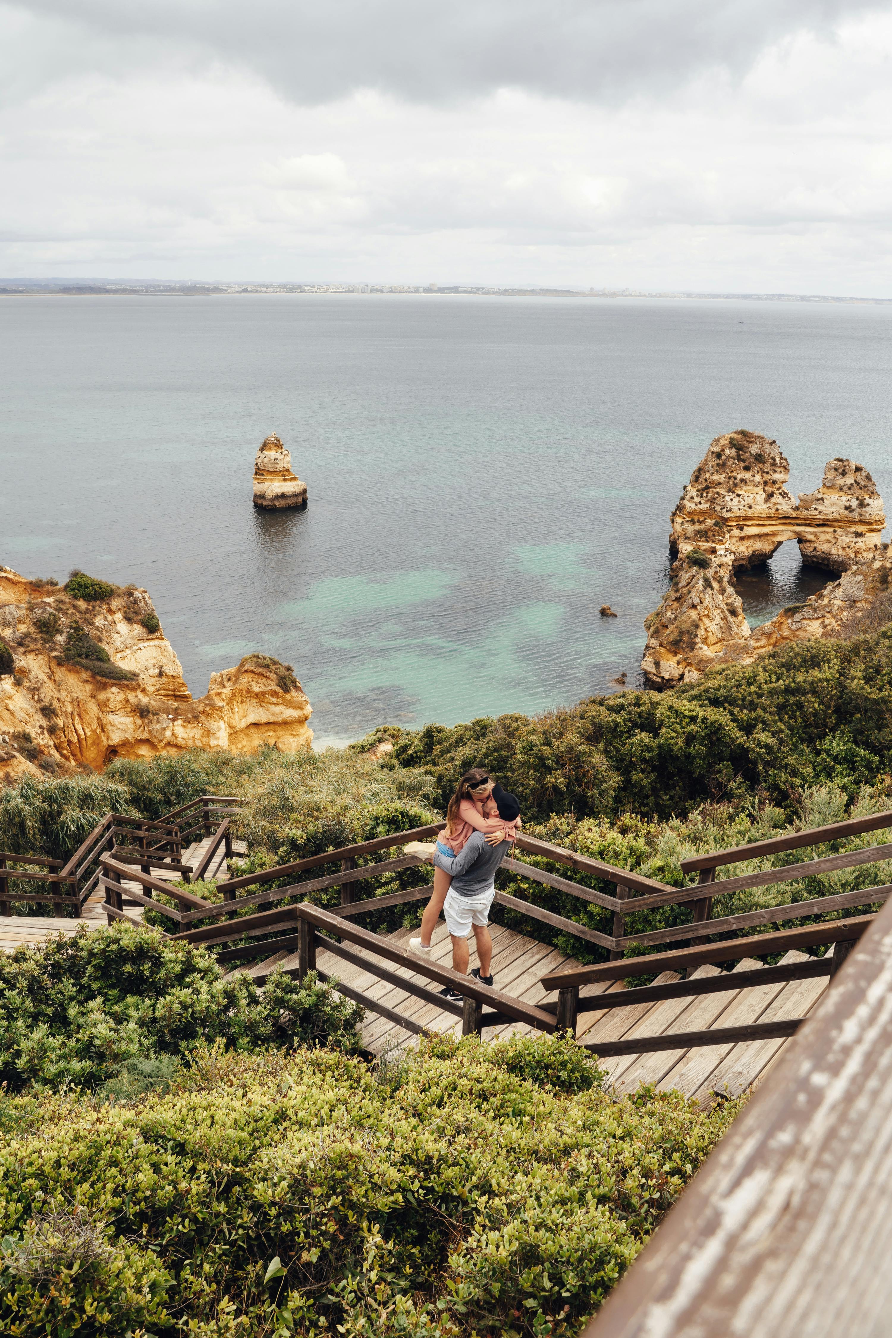 a couple kissing while on the cliff
