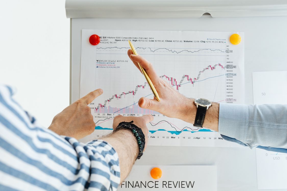 Free Professionals analyzing financial charts at a whiteboard meeting. Stock Photo