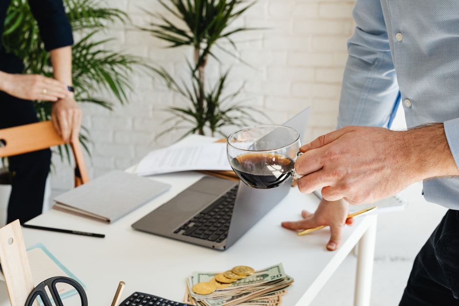 Term Life vs Whole Life for Young Families: Coverage & Cost Showdown Two people working at an office desk with coffee, laptop, and financial documents.