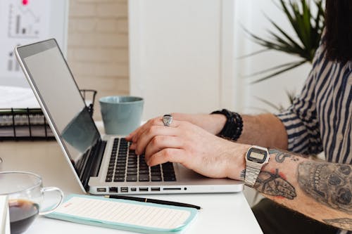 Tattooed Person Using Laptop 