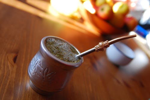 Taza De Té De Color Plateado Con Agitador Sobre Mesa De Madera Marrón