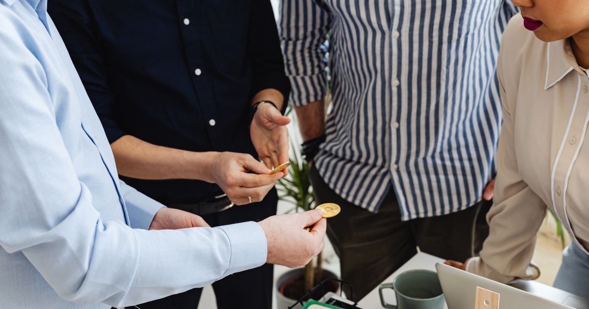 UK entrepreneurs networking at a startup expo, exchanging business cards and ideas.
