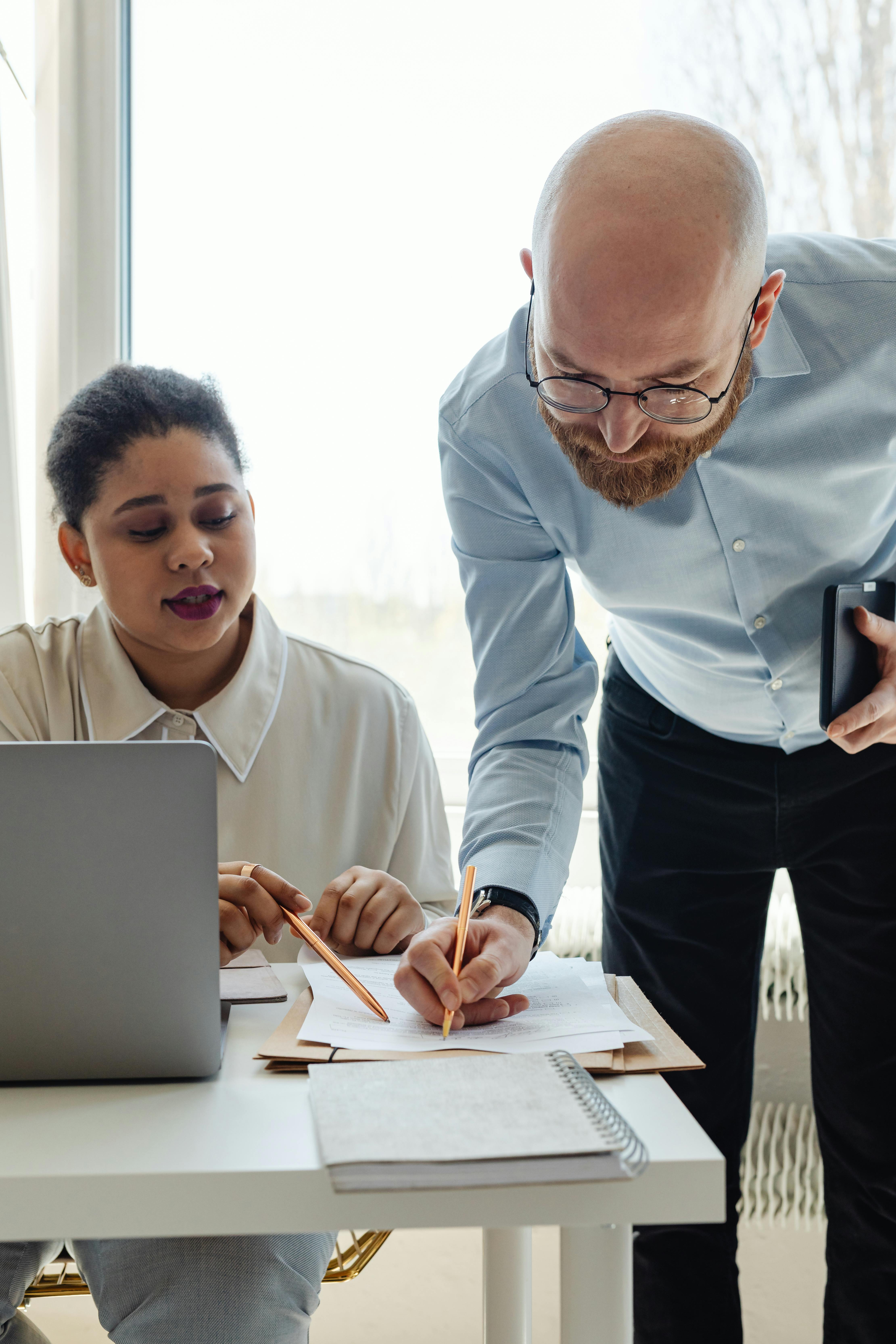Professional reviewing documents beside a laptop, representing clear documentation and trust signals for financial services