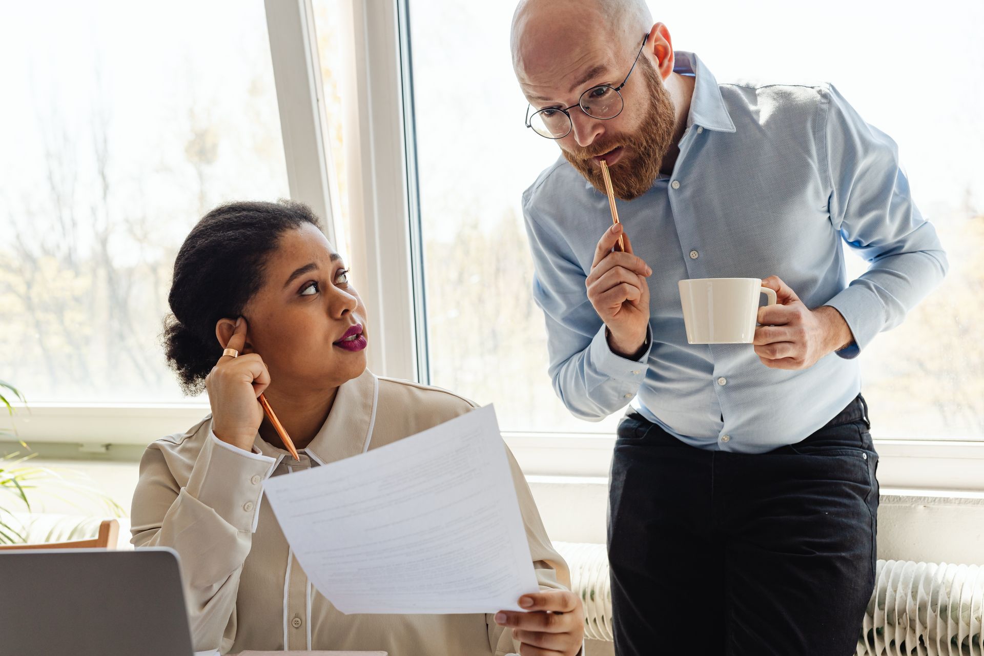 Two business colleagues reviewing documents together in a bright office.