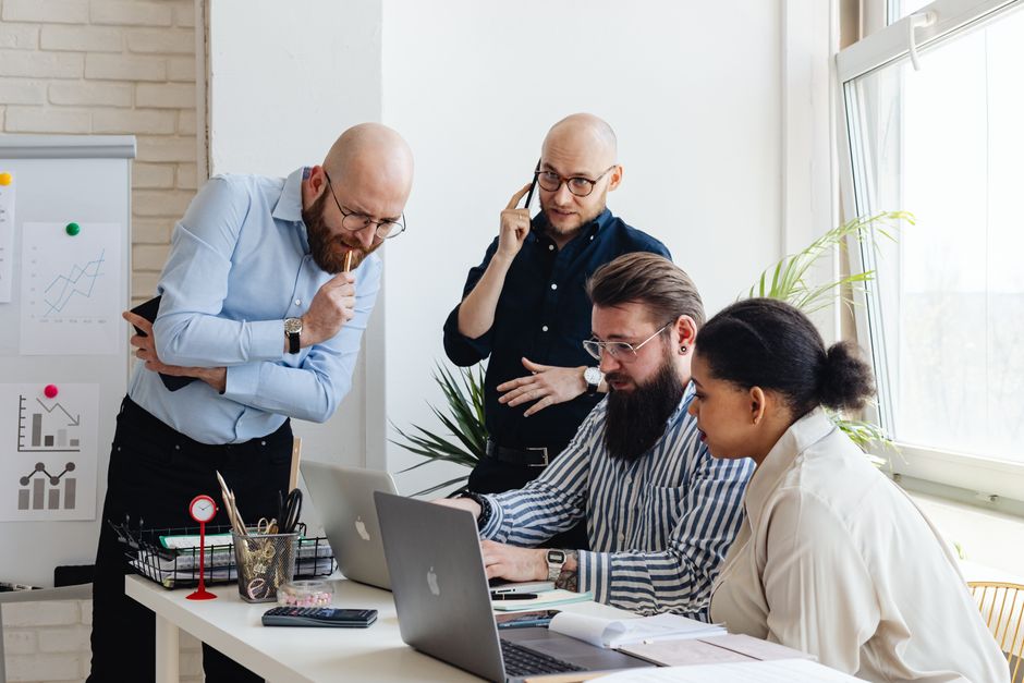 Multi-ethnic team collaborates on a project in a modern office setting, enhancing teamwork.