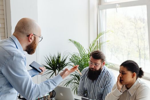 A heated discussion among colleagues in a bright office setting.