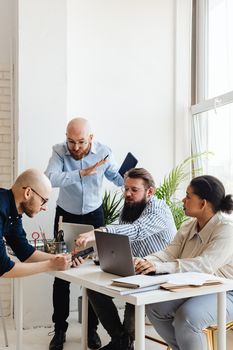 Group of professionals working together in a bright office, focusing on teamwork and collaboration.