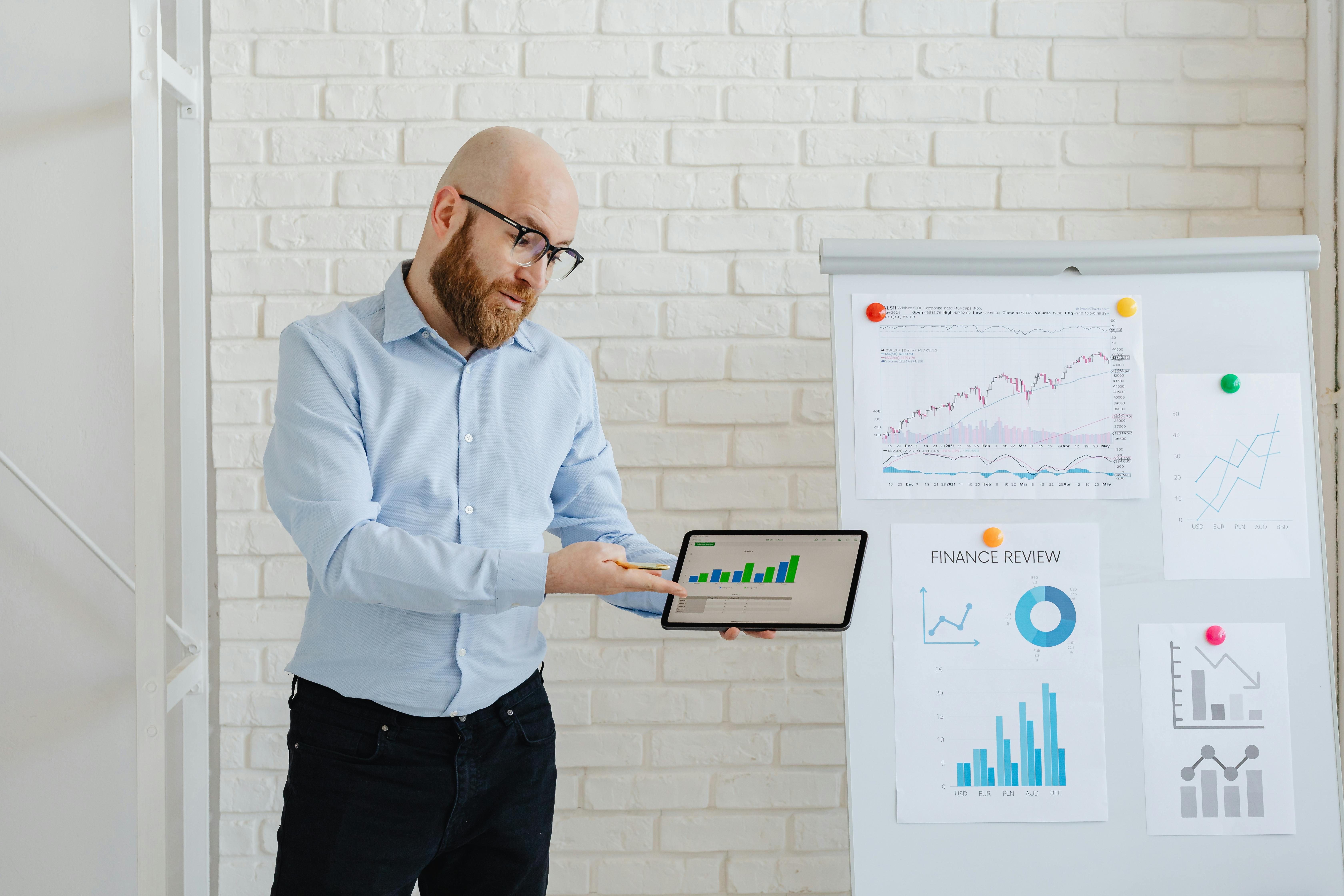 Man in Light Blue Long Sleeve Shirt Holding Black Digital Tablet