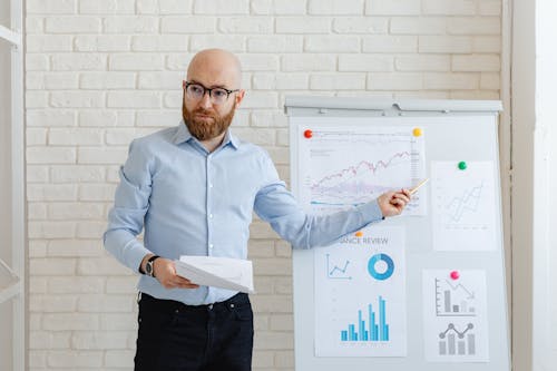 Man in Blue Long Sleeve Shirt Holding White Paper