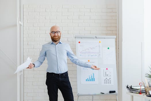 Confident businessman presenting financial data on a whiteboard in a modern office setting.