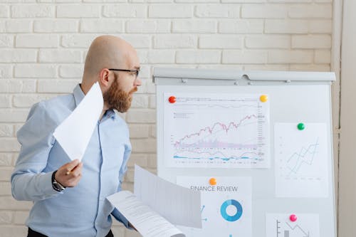 A Man Looking at Charts and Graphs on a Whiteboard