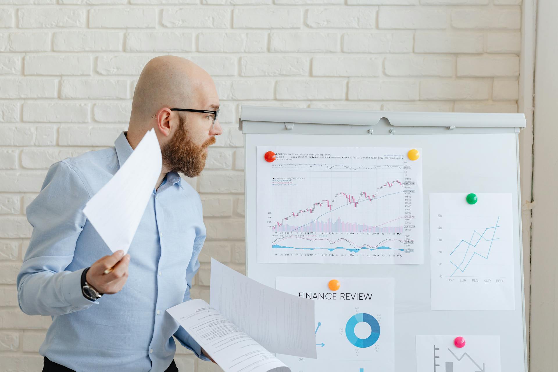 A Man Looking at Charts and Graphs on a Whiteboard