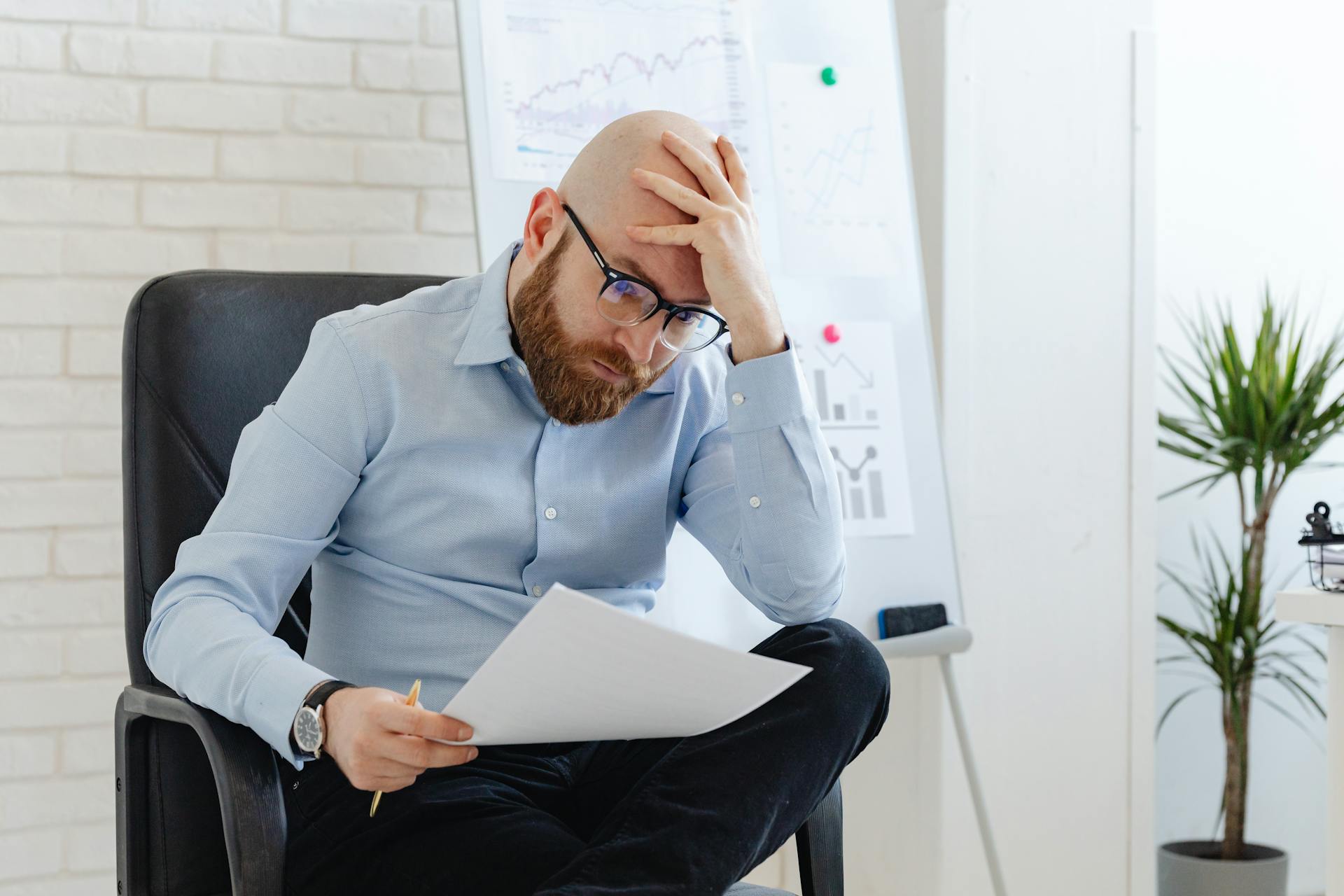 A 




















A Disappointed Man Looking at a Paper Holding his Head