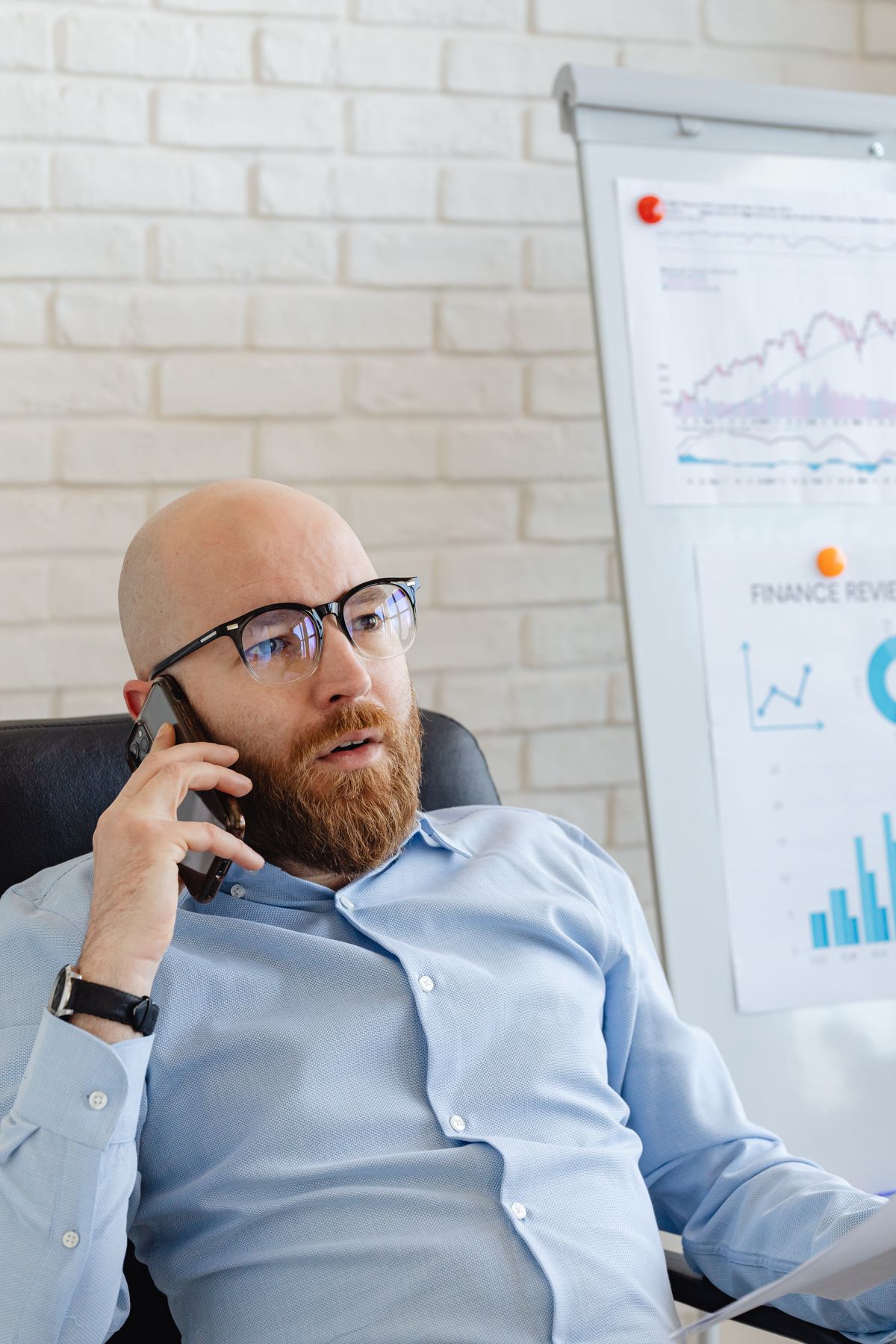 A businessman having a phone conversation in an office discussing financial charts