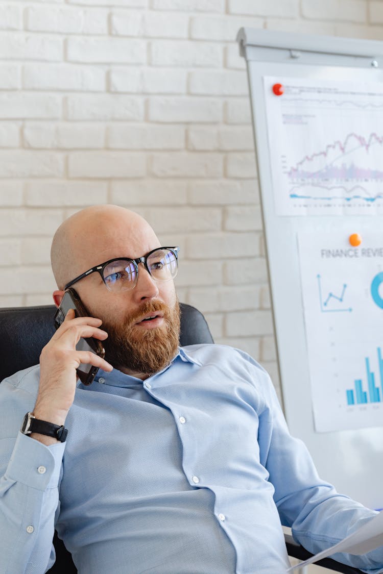 A Man Talking On The Phone At An Office