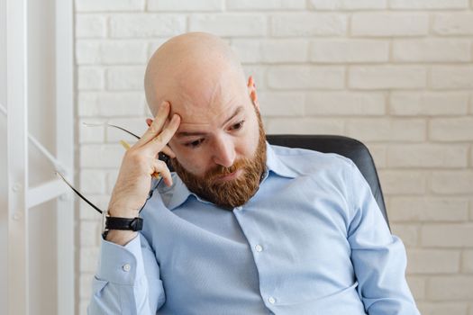Portrait of a thoughtful businessman in office attire, appearing stressed and contemplative.