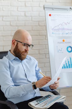 Caucasian businessman reviewing financial documents in a modern office setting.