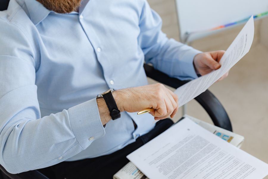 A founder reviewing hiring paperwork at a desk before sending an offer