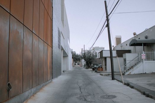 Desolate urban alleyway in Austin with modern buildings and power lines.