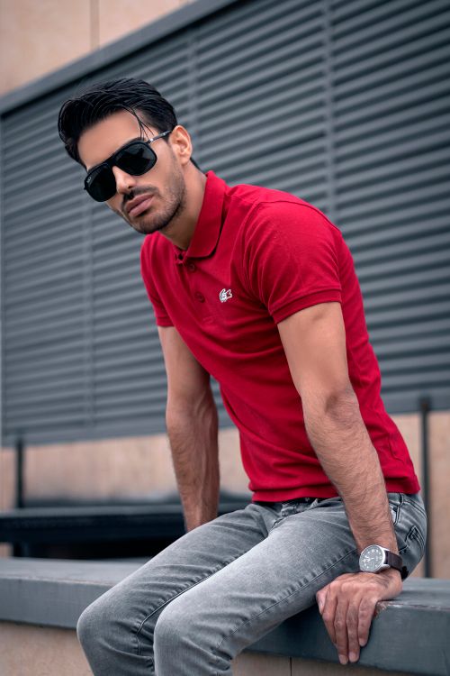 Free Fashionable man in a red polo shirt poses confidently outdoors in Tehran. Stock Photo