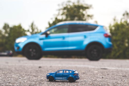 Free Blue Toy Car near a Blue Car  Stock Photo