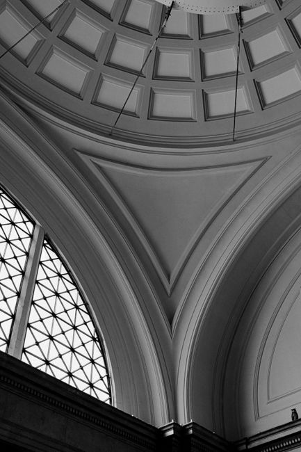 A striking black and white image of an architectural ceiling featuring intricate details and arches.