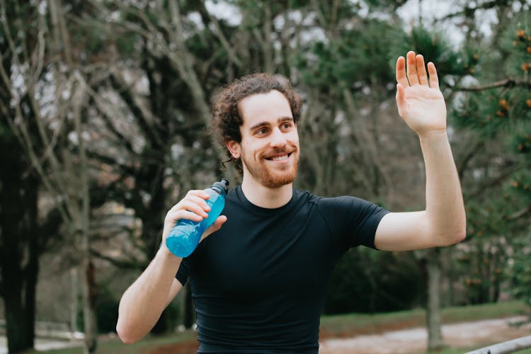 Happy Man Waving Hand In Park