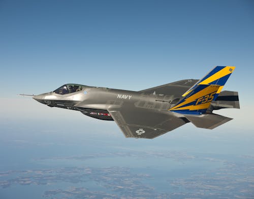 Free серо синий и желтый темно синий истребитель F 35, летящий на ясном голубом небе Stock Photo