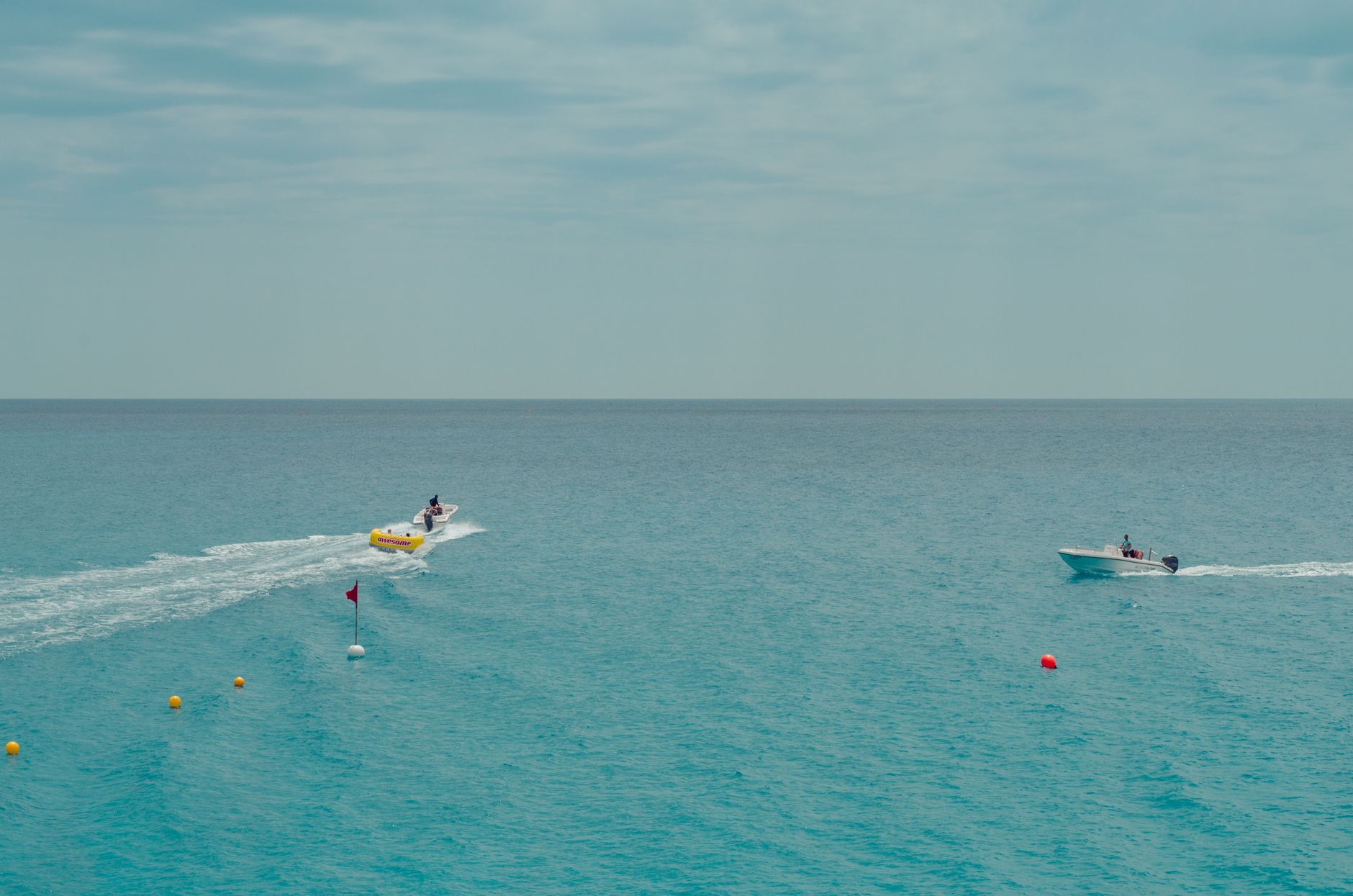 Boating on a serene blue sea with buoys in view, capturing leisure and recreation.