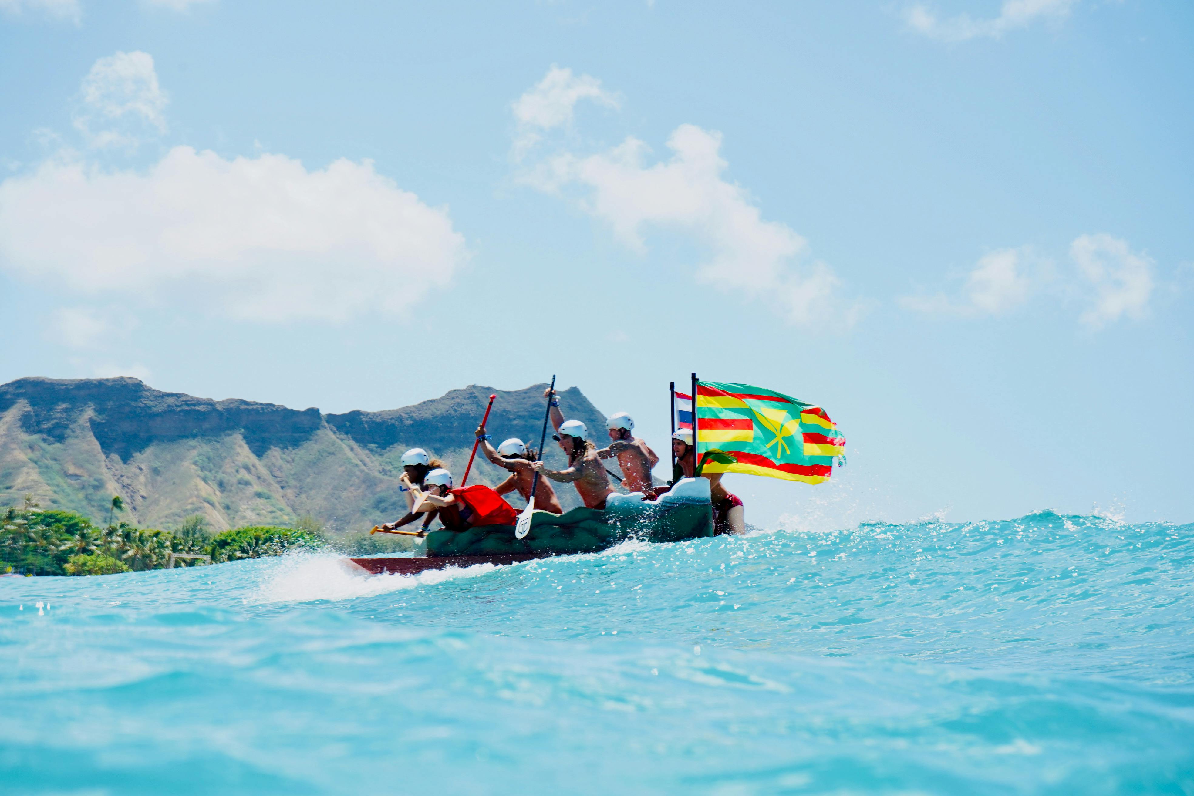 A Group of People Paddling a Canoe with Flags · Free Stock Photo