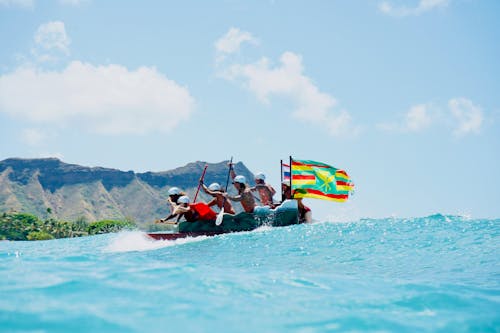 A Group of People Paddling a Canoe with Flags