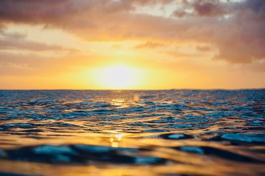 Mesmerizing view of the sun setting over the ocean, casting golden reflections on the waves.