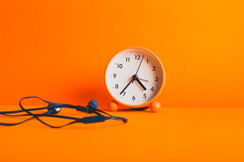 Orange Alarm Clock on Orange Surface 