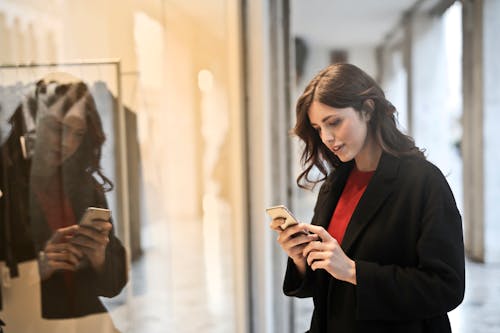 Foto De Primer Plano De Mujer En Abrigo Negro Con Smartphone