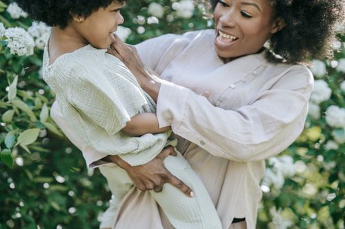 Free Playful interaction between mother and child in nature, full of laughter. Stock Photo