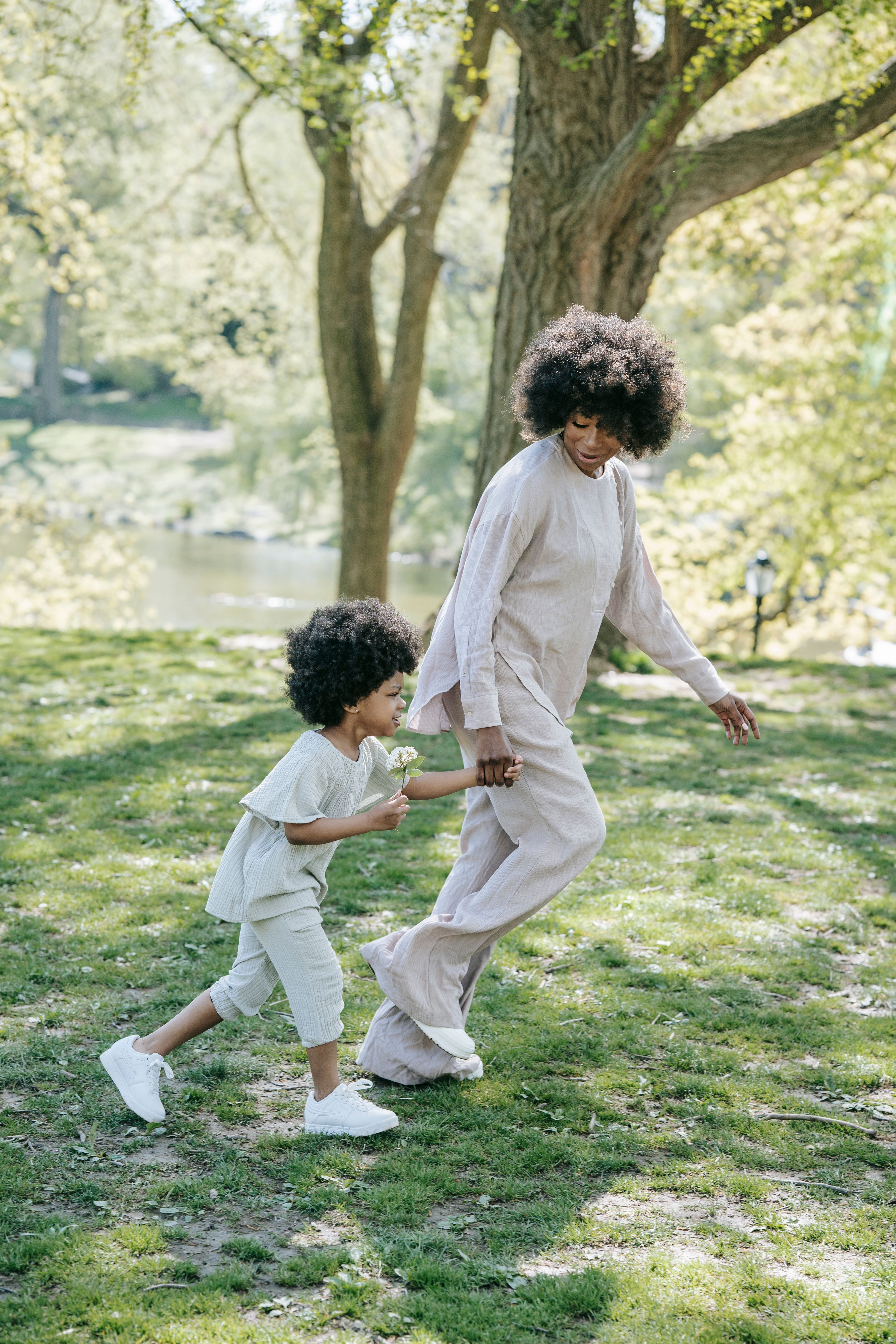 Joyful moment of a mother and child playing in a sunlit park, capturing togetherness and joy.
