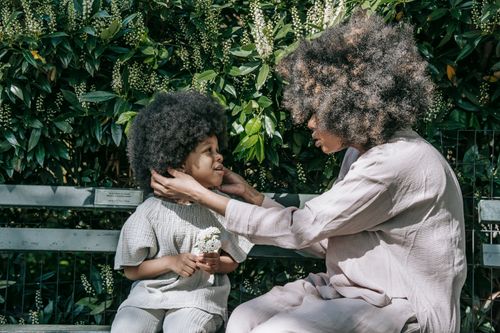 Free A touching scene of a mother and child bonding in a lush green park setting. Stock Photo