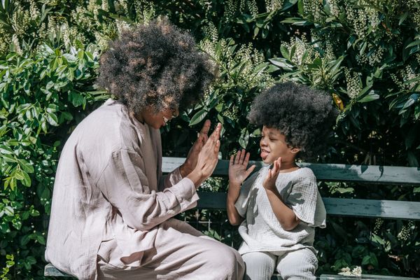 Mother and young child sharing a joyful moment on a park bench