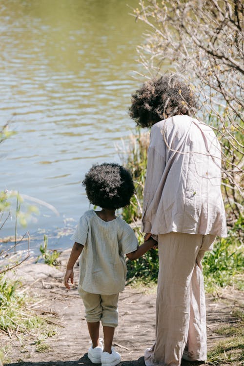 Back View of a Woman and her Child Standing by a Body of Water