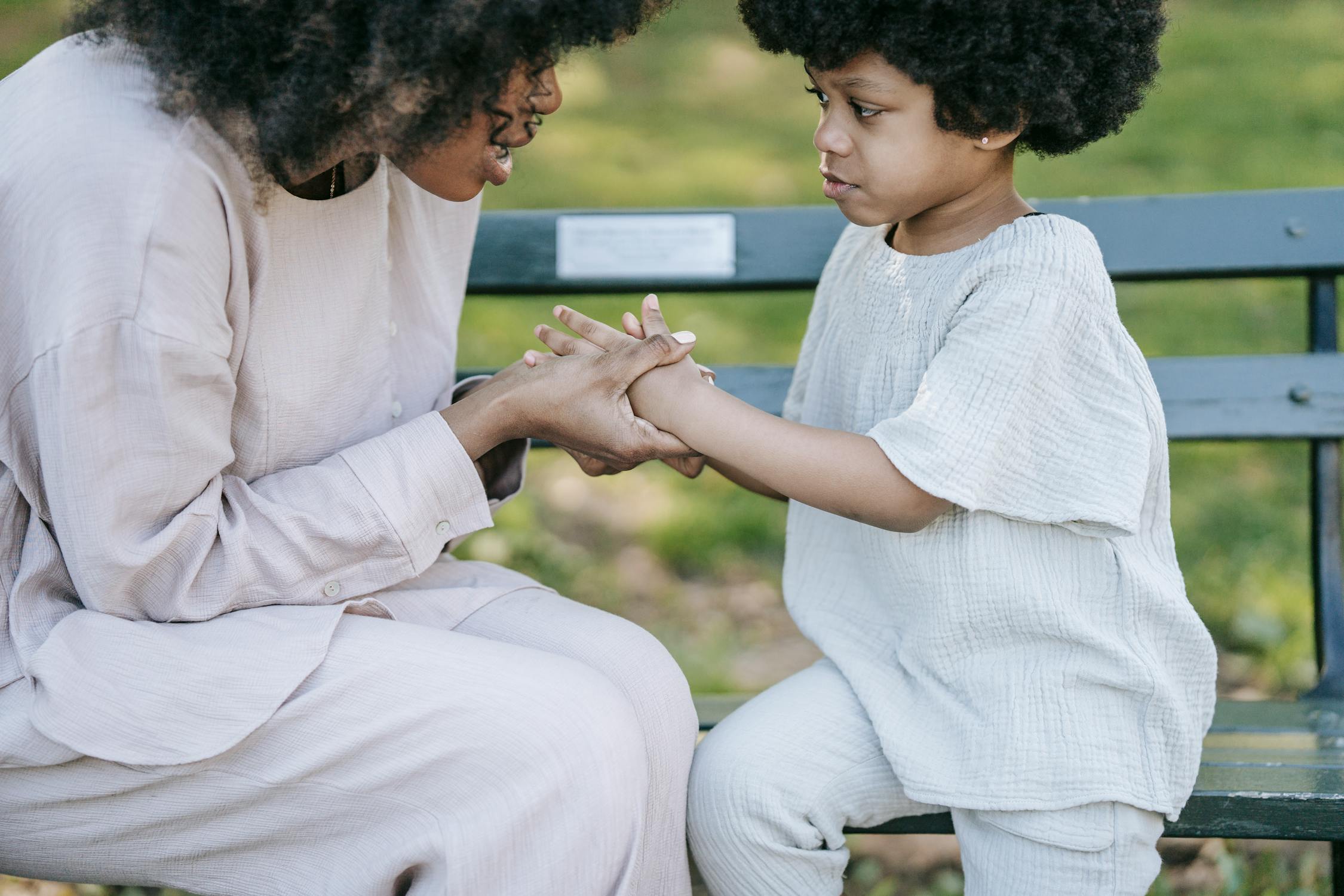 Woman Talking to Girl while Holding her Hands