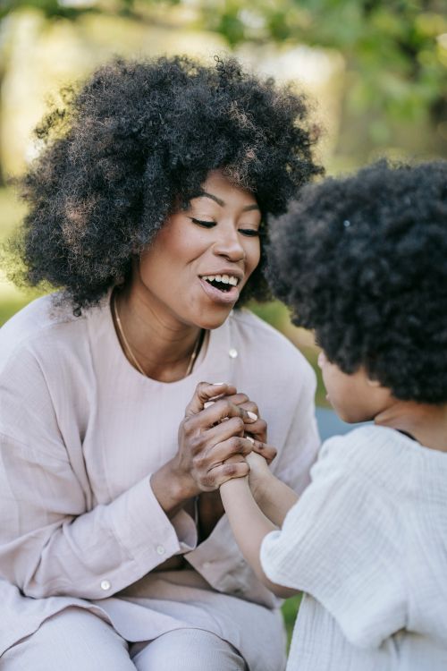 Free A joyful moment of a mother and son holding hands outdoors, showcasing their bond. Stock Photo