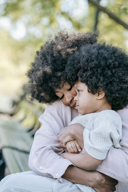 Free Mother and child sharing a warm embrace on a sunny day in the park. Stock Photo