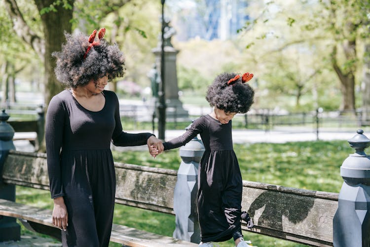 A Mother And Daughter In Black Clothing And Heart Headbands