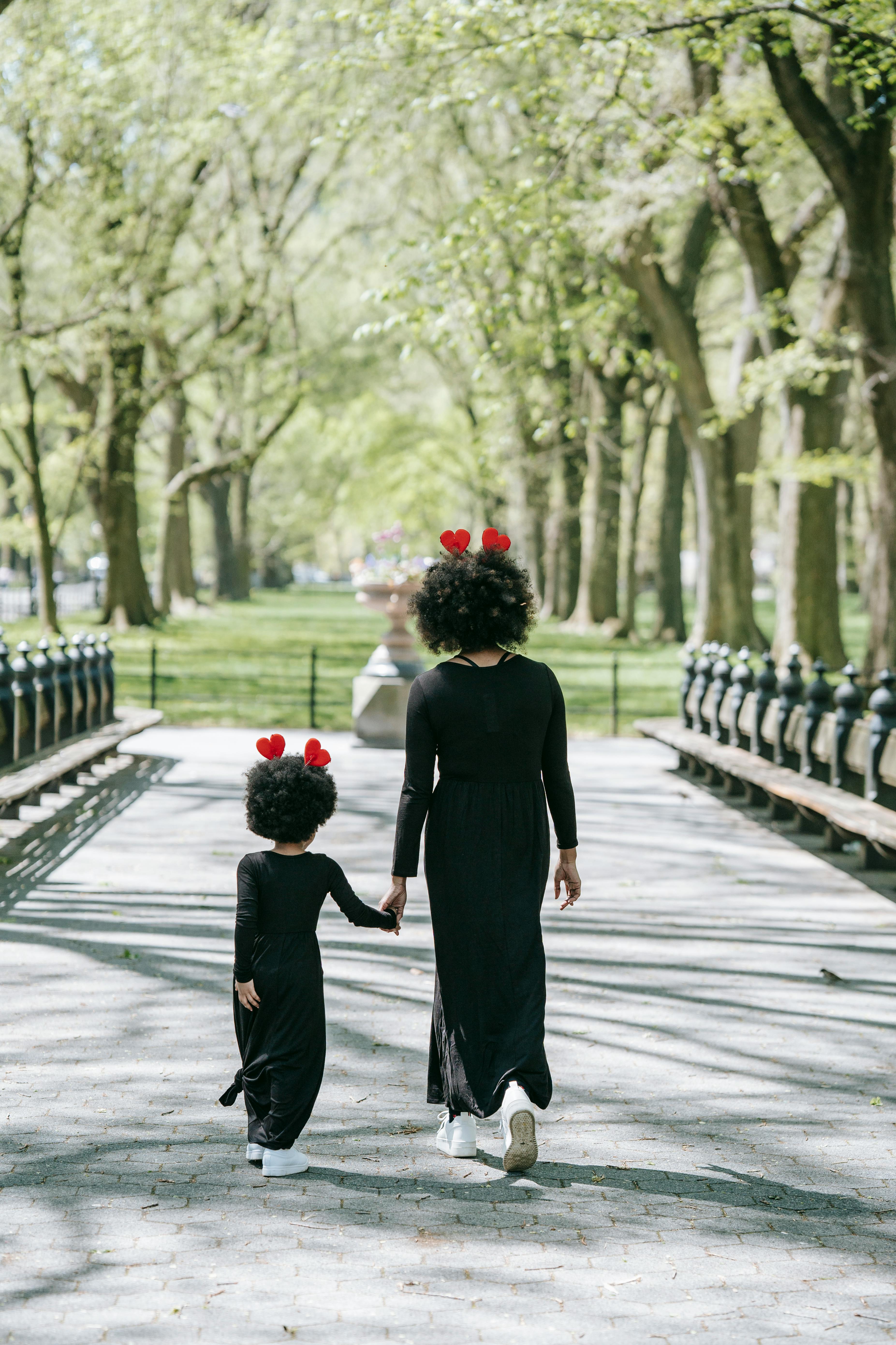 Mother And Daughter Walking In The Park Stock Photo - Download