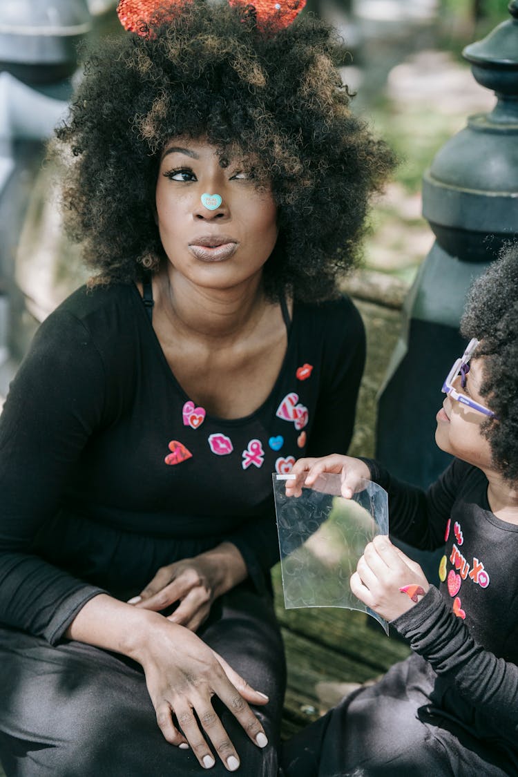 A Woman In Black Long Sleeve Shirt With Heart Sticker On Nose